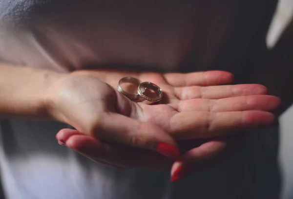 Woman hands holding wedding rings — Stock fotografie