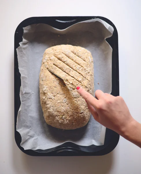 Mâini de femeie care fac linii pe pâine proaspătă de aluat — Fotografie, imagine de stoc