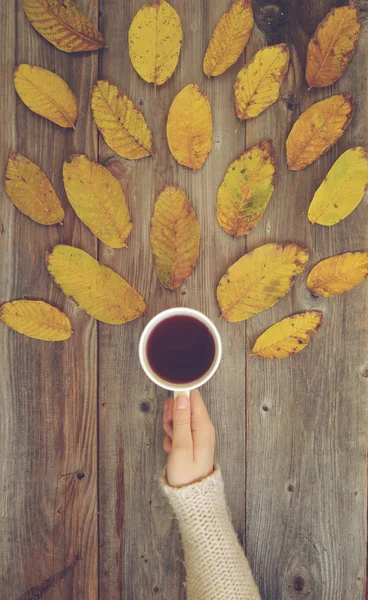 Flat lay view of woman drinking hot drink in cup on wooden desk — Φωτογραφία Αρχείου