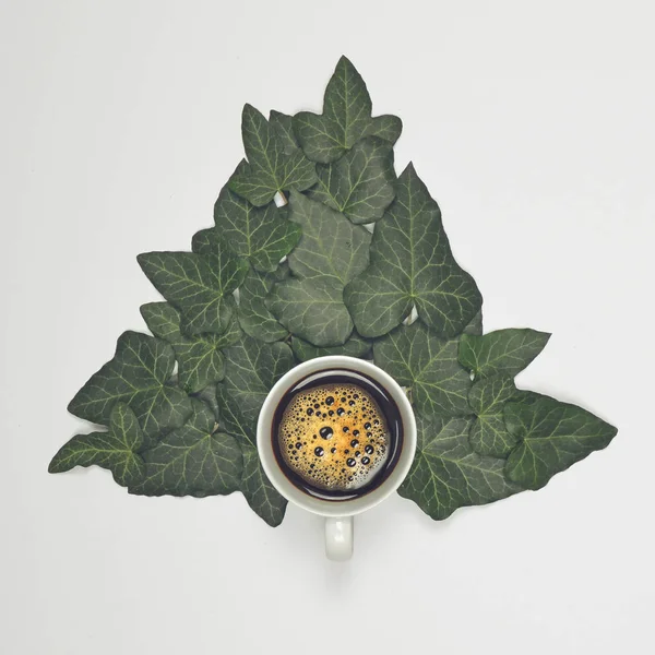 Perfekte Tasse Kaffee auf weißem Hintergrund mit grünen Blättern - fl — Stockfoto