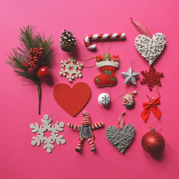 Плоская укладка рождественских украшений и орнаментов на розовой спинке — стоковое фото