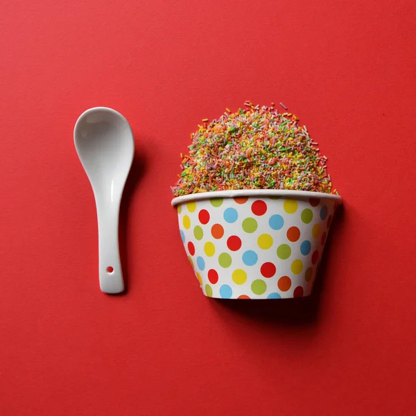 Copa de pastel lleno de caramelos multicolores espolvorea con pequeño spo — Foto de Stock