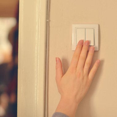 Kadın el duvar ışık için düğmeye basarak