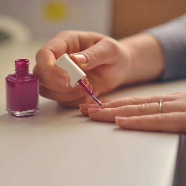 Mujer pinta sus uñas con esmalte de uñas rosa — Foto de Stock