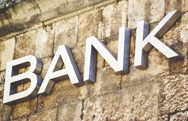 Banken tecken ristade i sten på byggnad — Stockfoto
