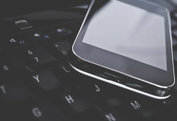 Cell phone on laptop keyboard — Stock Photo, Image