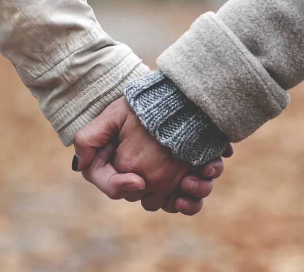 Close-up van paar hand in hand tijdens het wandelen in het park — Stockfoto