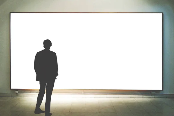 Man in gallery room looking at empty picture frames - Mock up ar — Stock Photo, Image