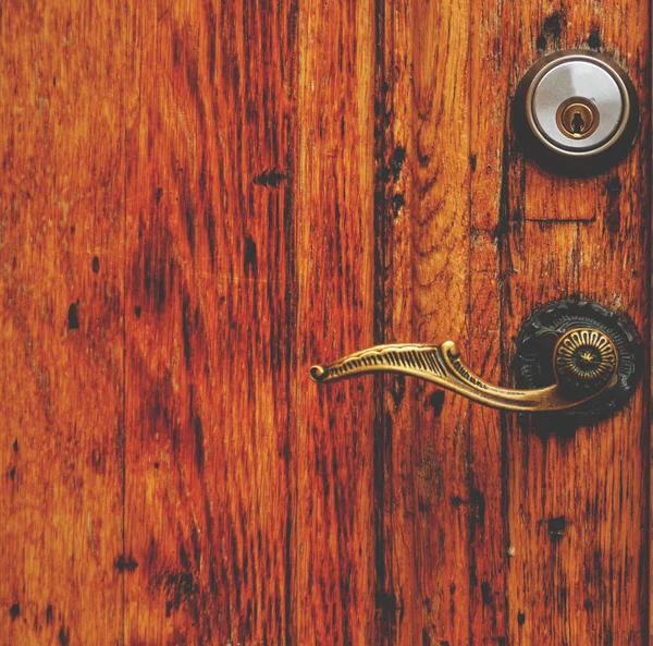 Porta de madeira velha com mão e fechadura de perto — Fotografia de Stock