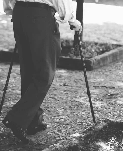 Homem sênior andando com pau de madeira — Fotografia de Stock