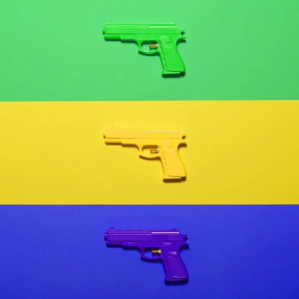 Pistolas de juguete sobre fondo colorido - Vista superior de diseño mínimo —  Fotos de Stock