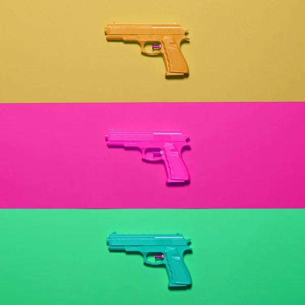 Pistolas de juguete sobre fondo colorido - Vista superior de diseño mínimo —  Fotos de Stock