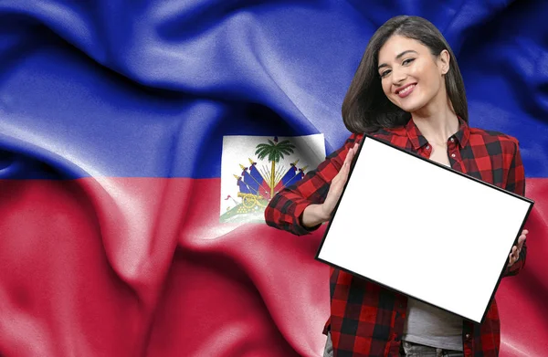 ハイチの国旗に対して空白のボードを持った女性 — ストック写真