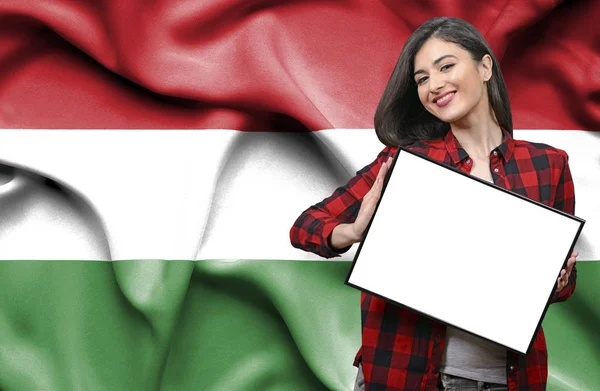 ハンガリーの国旗に対して空白のボードを持った女性 — ストック写真
