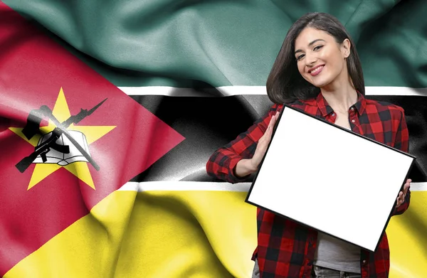 モザンビークの国旗に対して空白のボードを持った女性 — ストック写真