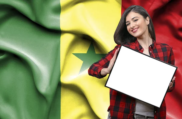 セネガルの国旗に対して空白のボードを持った女性 — ストック写真