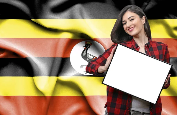 ウガンダの国旗に対して空白のボードを持った女性 — ストック写真