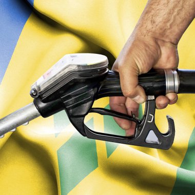 Benzin tüketimi kavramı - hortum karşı bayrak tutan el