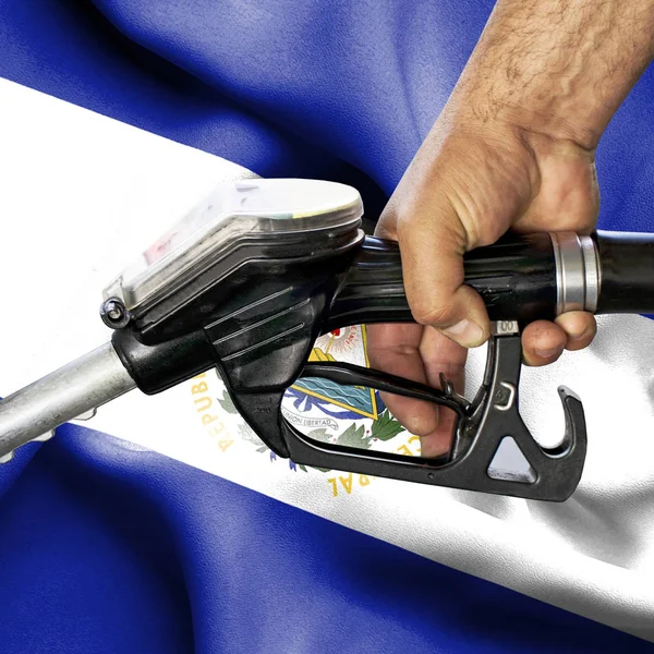 Conceito de consumo de gasolina - Mangueira de retenção de mão contra bandeira de — Fotografia de Stock