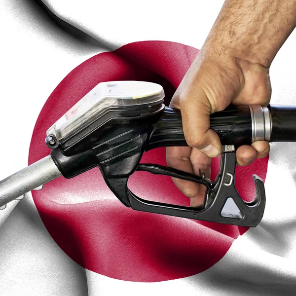 Концепція споживання бензину - Рука тримає шланг проти прапора — стокове фото