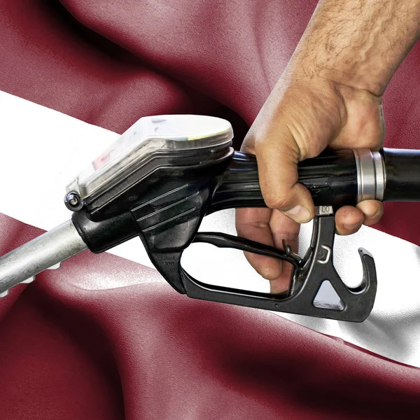 Conceito de consumo de gasolina - Mangueira de retenção de mão contra bandeira de — Fotografia de Stock