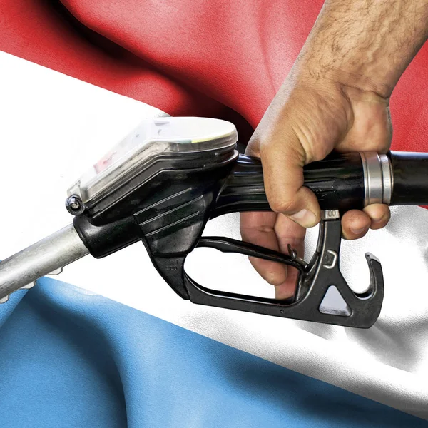 Concepto de consumo de gasolina - Manguera de mano contra bandera de — Foto de Stock