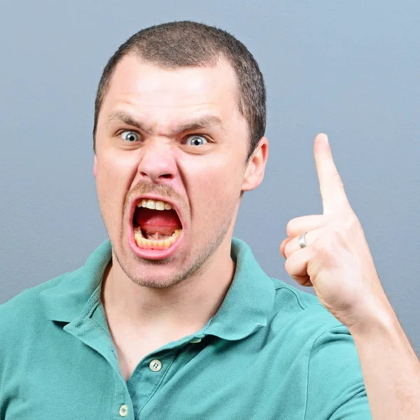 Portrait of a angry threatening man screaming against gray backg — Stock Photo, Image