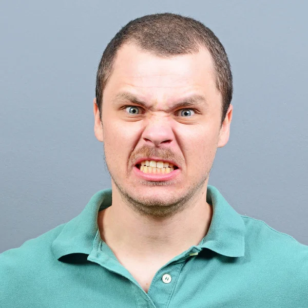 Portrait of a mad looking man against gray background — Stock Photo, Image