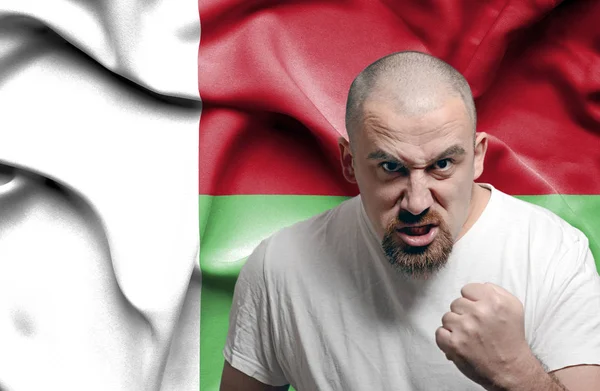 Angry man against flag of Madagascar — Stock Photo, Image