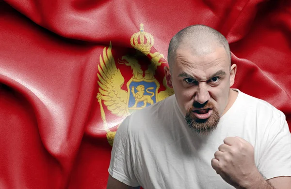 Wütender Mann gegen Flagge Montenegros — Stockfoto