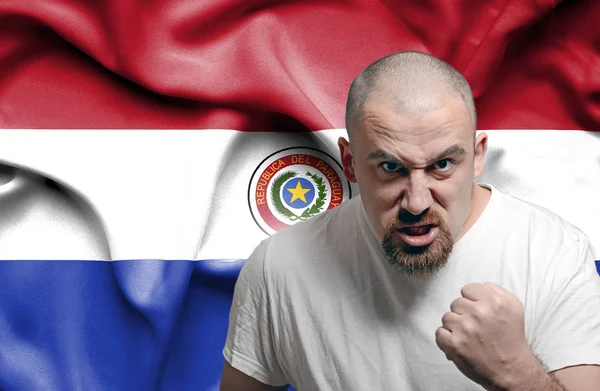 Сердитий людина проти прапор Парагваю — стокове фото