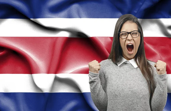 Mujer extática holidng puños y gritando contra la bandera de Costa — Foto de Stock