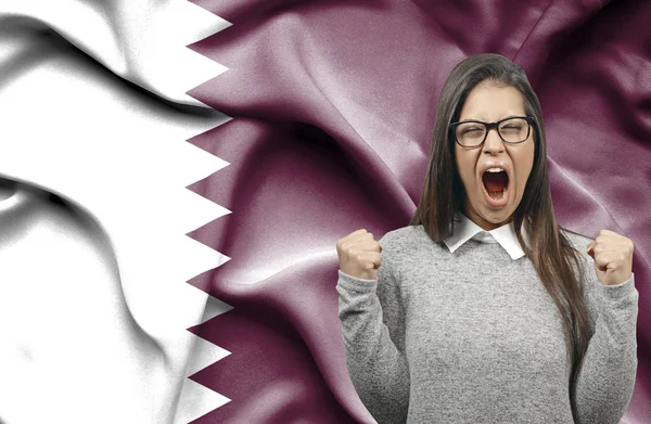 Extatisch vrouw holidng vuisten en schreeuwen tegen vlag van Qatar — Stockfoto