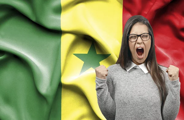 Ekstatyczny kobieta holidng pięści i krzyczeć przeciwko flaga Seneg — Zdjęcie stockowe