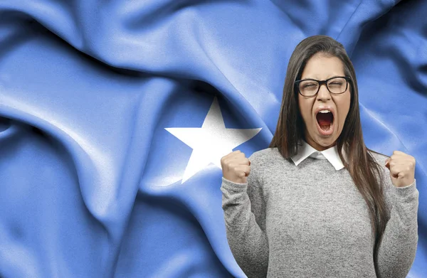 Mujer extática holidng puños y gritando contra la bandera de Somal — Foto de Stock