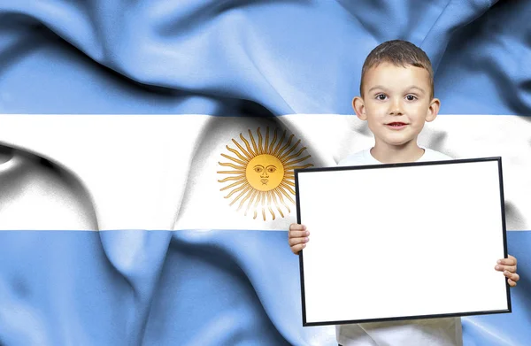Carino piccolo ragazzo che tiene il segno emtpy davanti alla bandiera di Argentina — Foto Stock