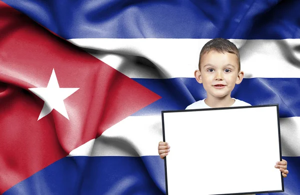 Carino piccolo ragazzo che tiene il segno emtpy davanti alla bandiera di Cuba — Foto Stock