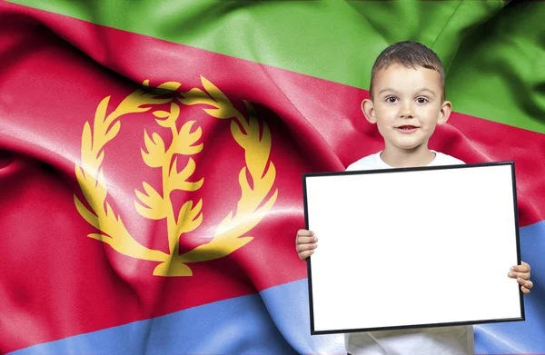 Lindo niño pequeño sosteniendo el cartel de emtpy delante de la bandera de Eritrea —  Fotos de Stock