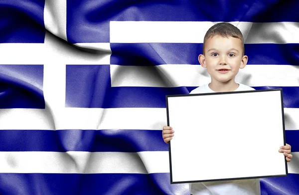 Niedlicher kleiner Junge mit emtpy Zeichen vor der Flagge von Griechenland — Stockfoto