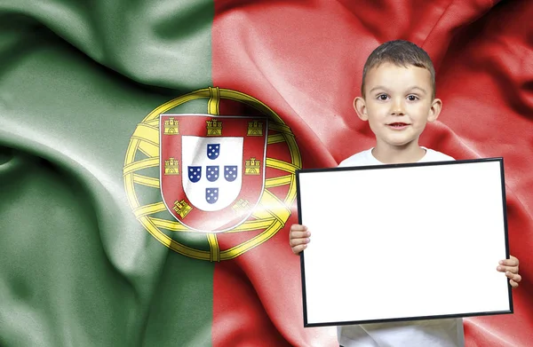 Милий маленький хлопчик тримає emtpy знак в передній частині прапор Португалії — стокове фото