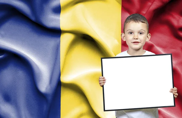 Schattige kleine jongen holding emtpy teken in de voorkant van de vlag van Roemenië — Stockfoto