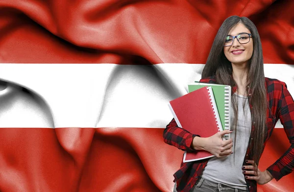 Happy female student holdimg books against national flag of Aust — Stock Photo, Image