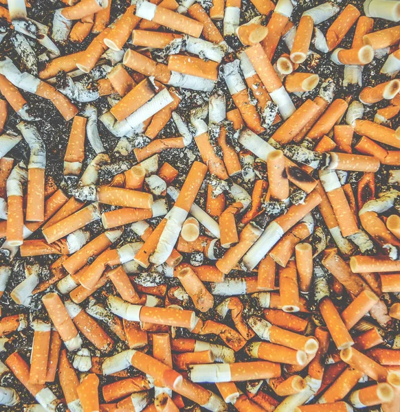 Cigarrillos ahumados colillas en un cenicero sucio — Foto de Stock