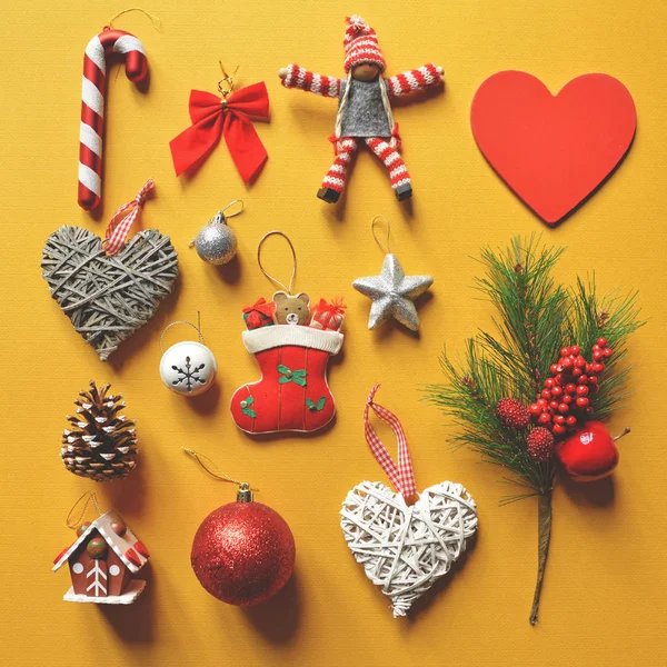 Плоская укладка рождественских украшений и орнаментов на желтом бэкгро — стоковое фото