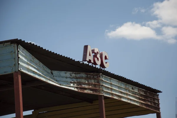 Velho posto de gasolina sobre o céu azul — Fotografia de Stock