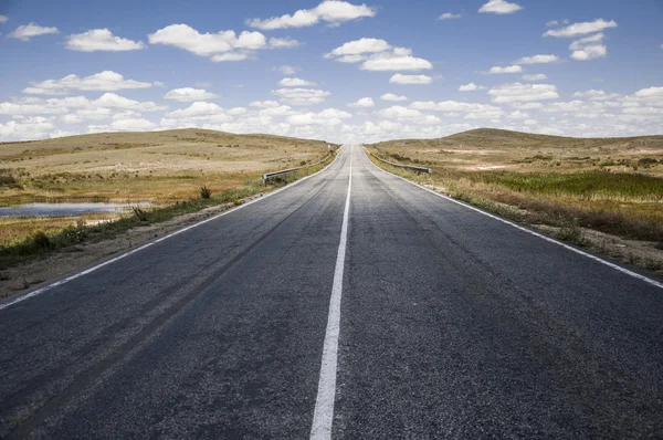 Asphalt road and clouds on blue sky in summer day — Stock Photo, Image