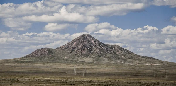 Le paysage pittoresque steppe avec montagne, steppes avec végétation clairsemée sur un fond de ciel bleu avec des nuages — Photo