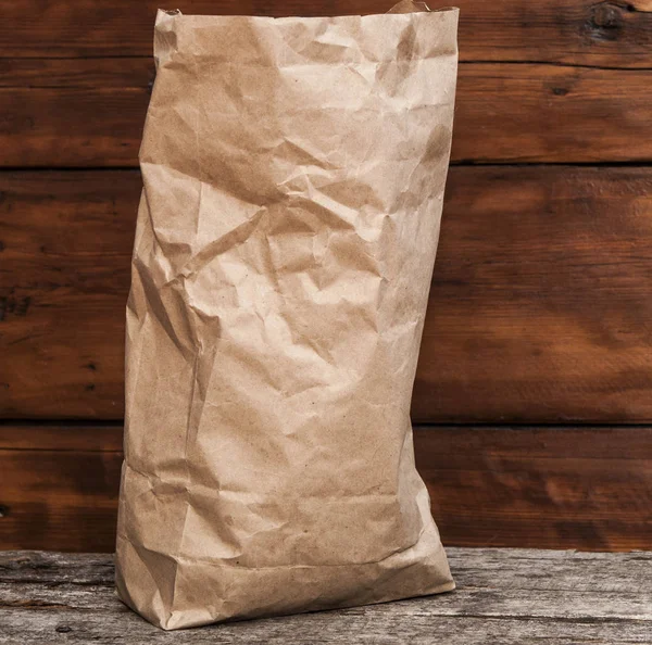 Paper bag on a wooden texture — Stock Photo, Image