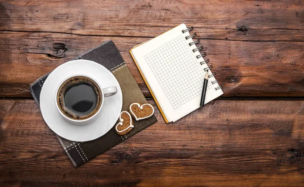 Coffee cup a Poznámka kniha na dřevěnou desku — Stock fotografie