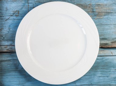 Ahşap bir arka planda boş beyaz tabak